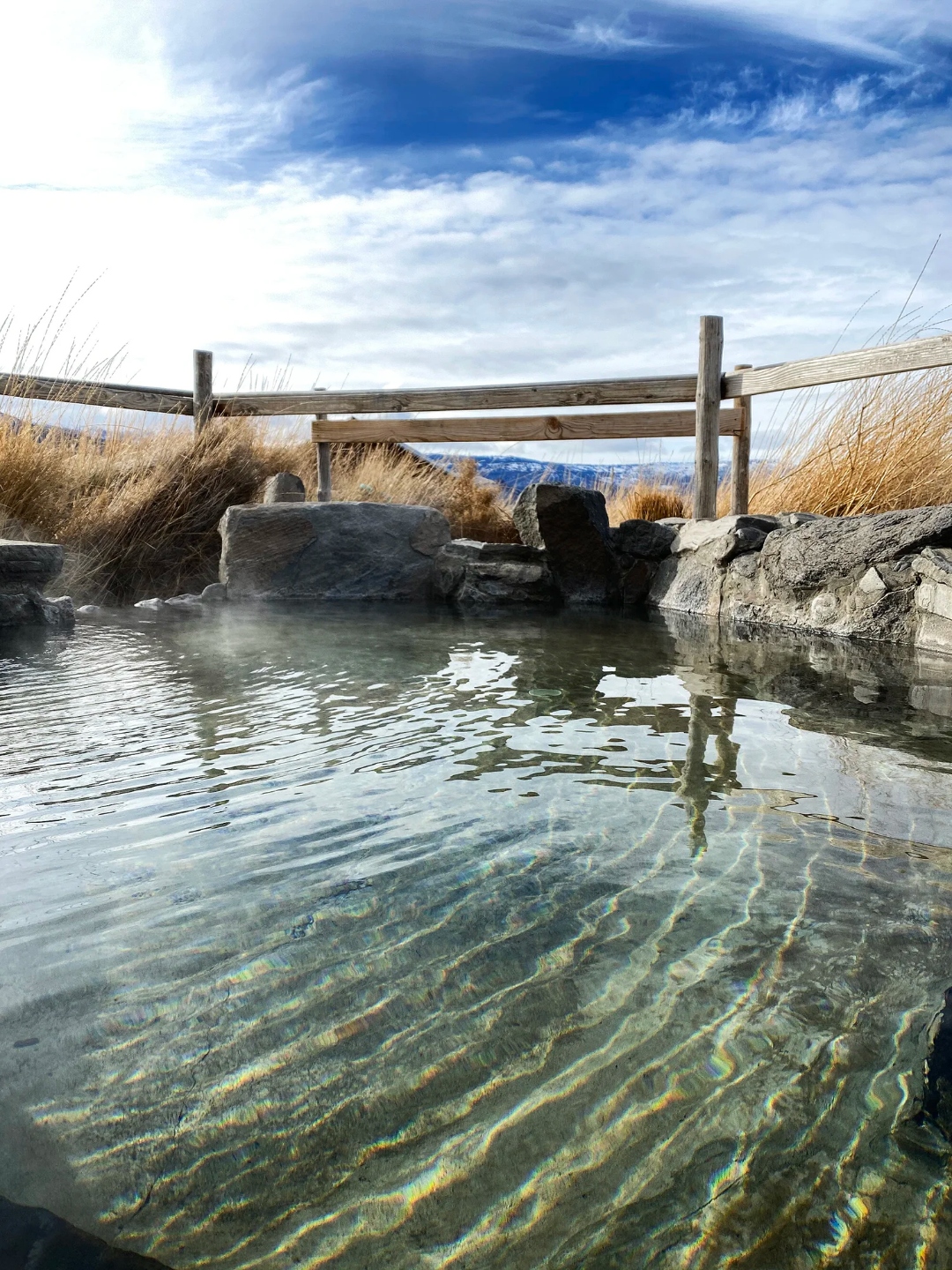Outdoor hot spring pool with blue sky and mountains at Summer Lake