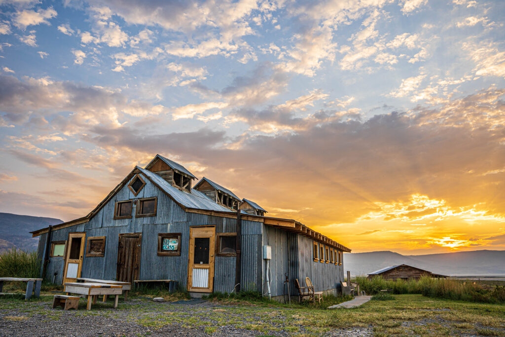 The iconic Summer Lake bathhouse against a dramatic golden sunset sky