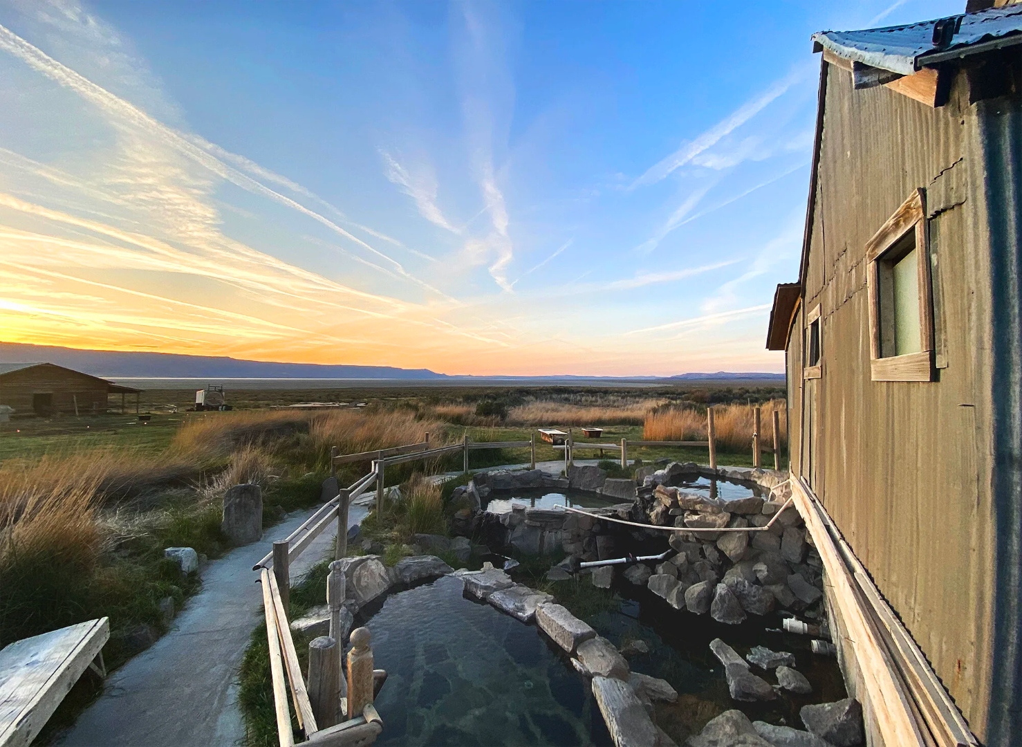 Outdoor rock soaking pools at Summer Lake Hot Springs at golden sunset